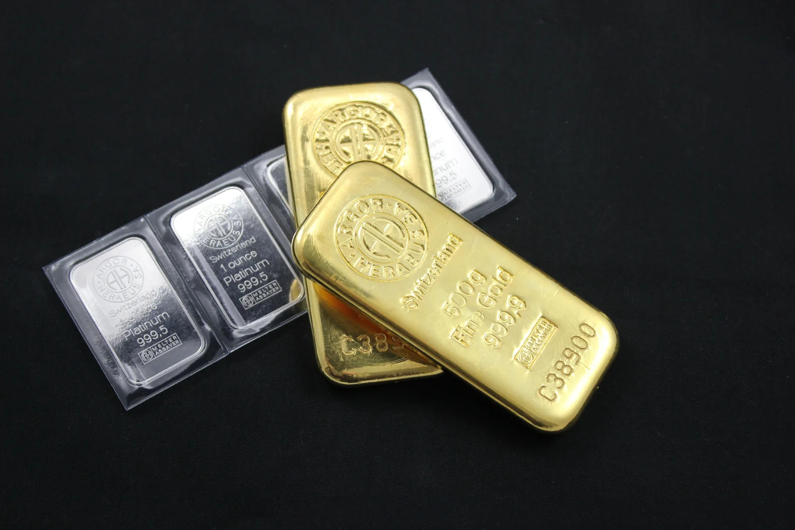 Gold and silver bullion bars on a dark surface